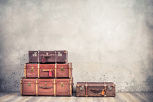 Vintage Classic Outdated Trunks Luggage With Tags, Old Antique Leather Suitcases Front Textured Aged Concrete Wall Background. Travel Baggage Concept. Retro Style Filtered Photo