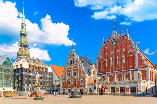 Wall Mural -  - View of the Old Town Ratslaukums square, Roland Statue, The Blackheads House and St Peters Cathedral against blue sky in Riga, Latvia. Summer sunny day