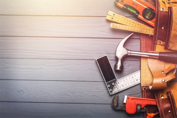 Tool belt with tools on wooden background