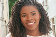 © Mangostar - Happy beautiful Afro American woman smiling at camera. Closeup of positive cheerful young black girl walking outdoors. People concept