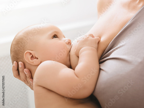 Fotografía Mother breast feeding and hugging her baby