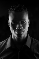 portrait of a african man on black background, serious