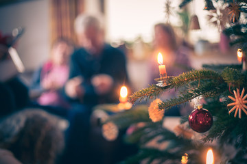 Traditional Christmas tree with Christmas decoration, evening. People in the blurry background.