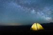 © Ambartsumian - tourist tent of yellow color against the night sky with the Milky Way