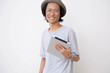 portrait of happy young asian man with fedora hat and glasses using tablet