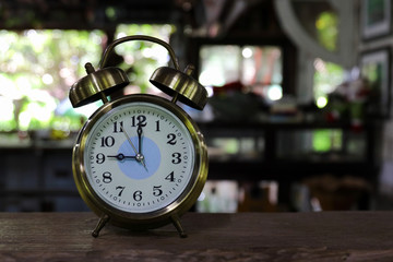 Old retro alarm clock on wooden table