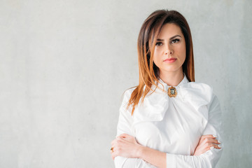 Wall Mural - Young woman portrait. Serious facial expression. Confident business female arms folded. Classy smart corporate ceo boss