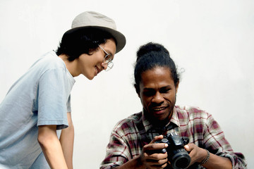 two friend of asian and black man using camera