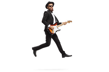 Canvas Print - Man performing with an electric guitar and jumping