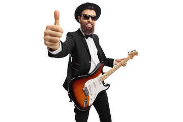 Canvas Print - Cheerful male guitarist with an electric guitar showing thumbs up