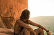 © Gary Parker/Stocksy - A young man watching the sunset Cathedral Rock, Sedona.