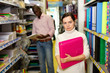 © JackF - Young female standing with folder for documents, during shopping with man  in stationery shop