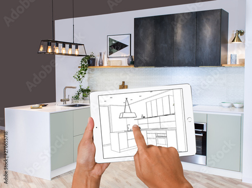Hands Holding Tablet Showing Kitchen Plans In Finished Room