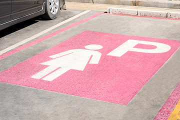 empty Lady parking lot symbol on the concrete street floor at petrol station, female priority public park area sign for women cars background