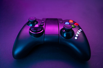 Gamepad on violet table background.