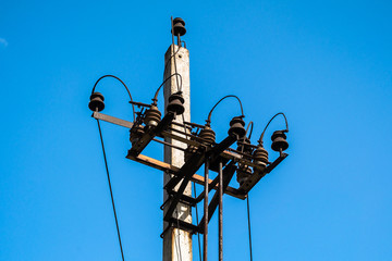 High voltage electric pole and transmission lines with clear blue sky. Electricity pylons. Power and energy engineering system. Danger high voltage tower. Cable wire on electric post. Power industry.