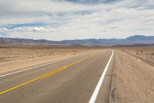 Death Valley Road Across The Desert To The Mountains In The Distance. California, USA