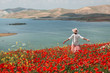 © Alexander Grabchilev/Stocksy - Young woman in a field of poppies.