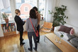 © Maskot - High angle view of real estate agent showing digital tablet to couple at home