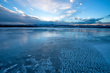 Wall Mural - Sunset Stormy Icy Lake - Sunset at a frozen solid mountain lake as a winter storm moving in. Chatfield State Park, Denver-Littleton, Colorado, USA.