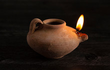 A Lit Handmade Oil Lamp From The Middle East On A Dark Table