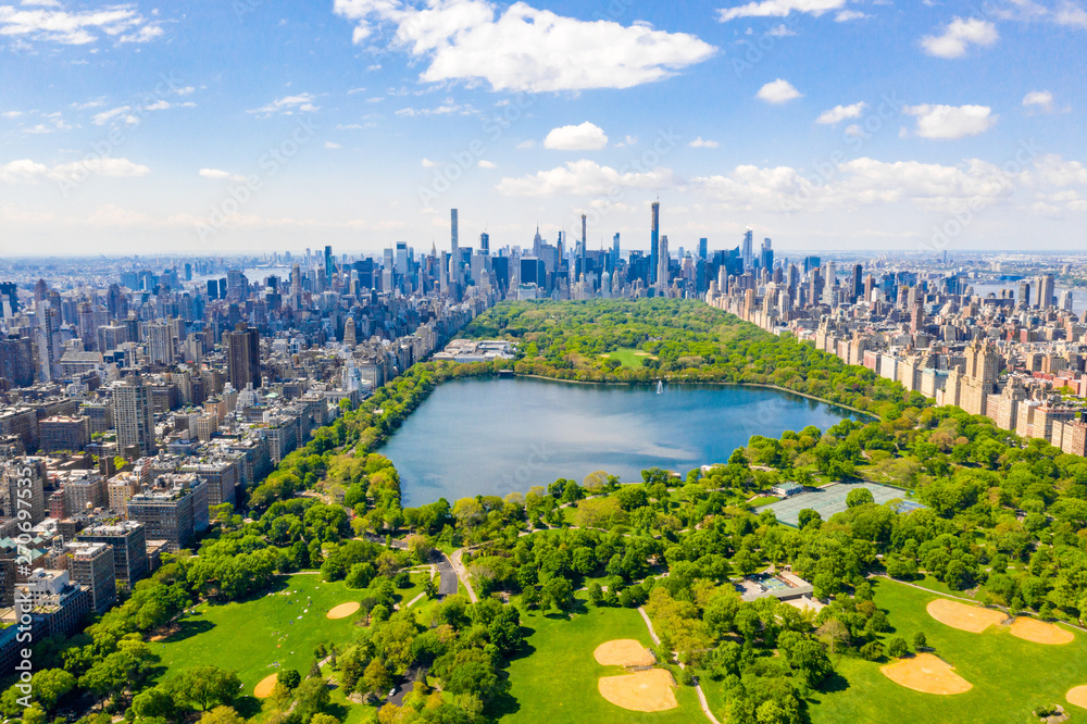 Aerial view of the Central park in New York with golf fields and tall skyscrapers surrounding the park. - obrazy, fototapety, plakaty 