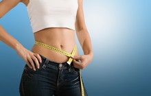 Slim Young Woman Measuring Her Thin Waist With A Tape Measure, Close Up