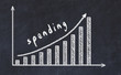 Chalkboard drawing of increasing business graph with up arrow and inscription spending