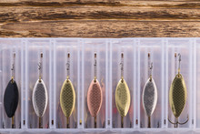 A Set Of Various Colors Of Iron Bait For Fishing In A Transparent Box