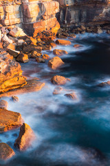 Canvas Print - long exposure view of wave water around rocks.