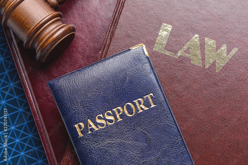 Judge's gavel, books and passport on table, closeup. Immigration law concept