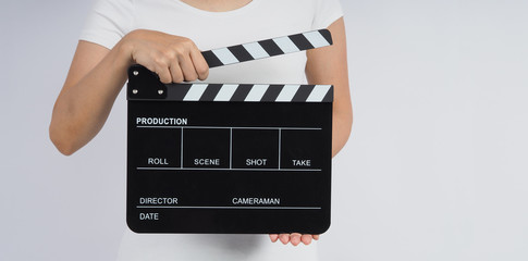 Hands is holding black Clapperboard or movie slate. it use in video production ,film, cinema industry on white background.