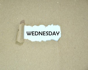 WEDNESDAY word on torn paper background.