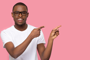 Wall Mural - Handsome man in glasses looking at camera pointing aside