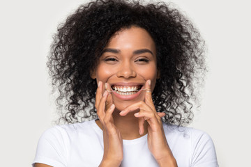 Closeup portrait happy african woman cleaning teeth with dental floss