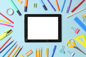 Modern digital tablet and school stationery on a colored background top view. Kontpt back to school. Place for text.