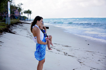 Canvas Print - Mom, holding little toddler boy with binoculars, observing dolphins