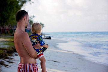 Canvas Print - Dad, holding little toddler boy with binoculars, observing dolphins