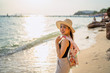 © etemwanich - portrait of asian beautiful girl in the relaxing in sea beach by wearing hat with sunset light