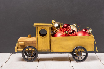 Wall Mural - Wooden car with red and golden Christmas balls in the back of a chalk board