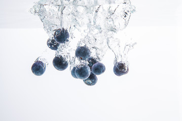 Wall Mural - Blueberries sinking underwater with air bubbles isolated on white background