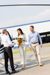 © LIGHTFIELD STUDIOS - husband and wife with flowers on romantic date walking near helicopter and pilot