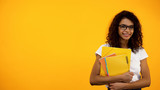 Fototapeta  - Smiling African-American student standing with books, educational programs