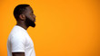 © motortion - Side view of young Afro-American male against yellow background, advertisement