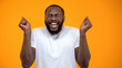 © motortion - Young Afro-American man feeling happiness, lottery winner, yellow background