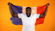 Excited black man holding French flag, supporting national sports team, cheering