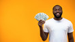 © motortion - Smiling African-American man showing bunch of dollars, template for text, ad