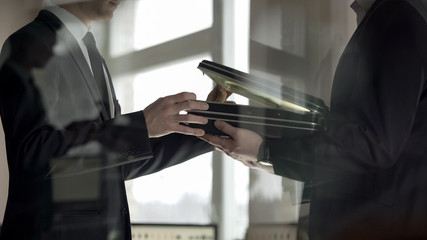 businessman checking dollars in briefcase, kickback in illegal cooperation