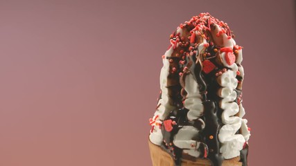 Wall Mural - Ice cream in waffle cone close-up. Ice cream with colorful sprinkles and chocolate syrup topping. Rotation. 4K UHD video footage. 3840X2160