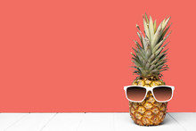 Hipster Pineapple With Sunglasses Against A Living Coral Colored Background. Minimal Summer Concept.